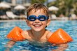 © Ksu_Sha - Happy child swimming in pool with goggles and arm float enjoying summer vacation fun water activity