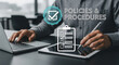 © DA_STOCK - Man reviewing policies and procedures document on tablet and laptop