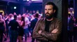 © ArtMajestic - Bearded man standing alone in crowded nightclub. Lonely male in casual leather jacket relaxing at party. Social isolation in public space. Emotional mood and introversion concept