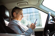 © Davor - Mature businesswoman using smartphone in parked car