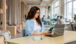© Rendara Studio - Connected business woman using smartphone linked to laptop with digital sync interface