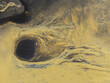 © AmazingAerialAgency - Aerial view of abstract patterns of orange sediment and a dark circular pool in a glacial river delta in Hallgeirseyjarvegur, Rangarthing eystra, Iceland.