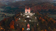 © AmazingAerialAgency - Aerial view of the Kalvaria Banska Stiavnica complex on a hill surrounded by autumn forests in Banska Stiavnica, Banskobystricky kraj, Slovakia.
