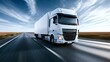 © Oleh - White semi truck driving fast on a straight highway with a blue sky and motion blur around, representing concepts of logistics, delivery, freight, and global shipping