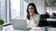 © Vasiliy - Asian businesswoman with glasses thinking while looking at laptop screen. Focused female corporate employee working at desk in modern office. Problem solving and business strategy concept
