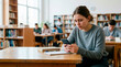 © Xenia - Anxious young female student looking at a smartphone in a library. Worried college woman reading a text message while studying