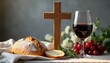 © Vadym - Communion bread and red wine beside wooden cross on table. Grapes and rosemary garnish. Christian sacrament of Eucharist meal for faith and spiritual connection.