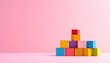 © dono2 - Colorful Building Blocks in Lower Corner with Pink Copy Space. Bright colorful educational building blocks arranged in the lower right corner of a pastel pink background with huge empty copy space.