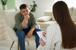 © New Africa - Psychologist making notes during therapy session with client indoors, selective focus