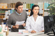 © JackF - Man with a medical prescription is standing near a pharmacist, they are checking for pills and medications on the computer. Buyer in a pharmacy consults with a pharmacist about the choice of medicines