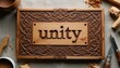 © Pete - Ornate Celtic wood carving with word unity. Detailed interlaced knotwork border frames central text. Tools and wood pieces suggest craft process.