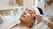 © Coosh448 - Korean man receiving a relaxing facial skincare treatment in a modern clinic, anti-aging and rejuvenation concept with eyes closed, calm expression and professional aesthetic care, macro eye area