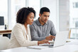 © Meow Creations - Two professionals looking intensely at a laptop screen in a bright modern office