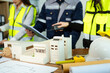© Nuttapong punna - Creative architect projecting on the big drawings with architectural project at construction site at desk