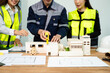 © Nuttapong punna - Creative architect projecting on the big drawings with architectural project at construction site at desk
