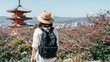 © CrazyJuke - Wandering in Kyoto: A traveler, hat-clad and backpack-laden, gazes upon a traditional pagoda, immersed in the allure of Kyoto's timeless beauty.