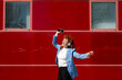 © VISTA by Westend61 - Businesswoman dancing outdoors with headphones and smartphone