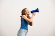 © VISTA by Westend61 - Activist in blue shirt shouting through megaphone outdoors