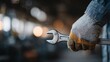 © JP - Industrial worker holding wrench in factory setting close-up perspective on protective gear and tools