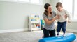© xuxu - Woman therapist guiding young boy with leg braces on parallel bars during walking exercise. Pediatric physical therapy session in rehabilitation