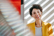 © BusinessClass by W61 - Smiling businesswoman in yellow blazer at modern office window