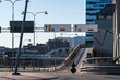 © yaqui_villegas - Motorcyclist on motorcycle riding road bridge in Stockholm Sweden with urban traffic in daylight depicting commuting mobility and city transport lifestyle