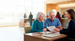 © Xenia - Senior couple reviewing financial document with female advisor in bank. Happy older man and woman consulting with professional agent at desk. Retirement planning concept