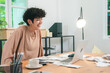© chokniti - Young woman curly hair casual clothing home office remote work laptop happy smiling paperwork coffee cup modern workspace freelance small business online meeting video call startup entrepreneur