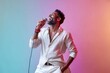 © Markus Schröder - Portrait of a glad indian man in his 40s dancing and singing song in microphone isolated on pastel or soft colors background