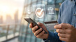 © IMAGES HUB - Business professional holding a smartphone and credit card with digital banking interface overlays showing successful transaction verification and account security icons outdoors