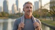 © nyul - Senior man doing sport activity in city park. Sporty middle aged 50s male with gray hair having morning training routine. Outdoor workout for fitness and wellbeing. Healthy lifestyle in older age.  .