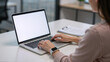 © AmDmLib - Woman working on laptop in modern office