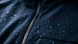 © Oleh - Dark blue waterproof jacket fabric repelling numerous water droplets, showcasing its protective and water resistant qualities against rain and moisture, featuring a prominent zipper