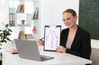 © New Africa - English teacher giving online lesson via laptop at white desk in classroom