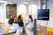 © littlewolf1989 - Conference room sign with blurred business colleagues discussing during a corporate meeting