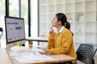 © David - Asian woman analyzing business data on computer in office