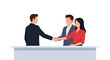 © Naim - Three professional business colleagues stand behind a sleek desk while two of them shake hands to finalize a successful partnership deal.