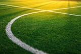 Close up view of green soccer field with white line markings during sunset showing texture and shadows. High quality photo