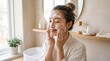 © Thipsuda - Young woman cleansing face with foaming cleanser in bathroom enjoying skincare routine natural light healthy skin relaxation morning self care Asian ethnicity home interior