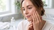 © Thipsuda - Woman applying facial toner with gentle touch glowing skin natural light skincare routine healthy complexion serene expression home bathroom self care beauty wellness
