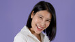 © blueringmedia - Smiling Asian Woman Laughing Against a Solid Purple Studio Background