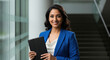 © PRASANNAPIX - young indian business woman holding book and coffee cup standing at office