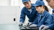 © 望見 柿元 - 日本人製造業のチームが青いユニフォームを着て精密機器の電子部品を共同で点検・修理している様子、回路基板を囲んで作業する工場の専門スタッフ