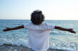 © SISMIZ - Woman with arms outstretched embracing the ocean breeze on a sunny day
