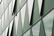 © yaqui_villegas - Abstract corporate story in reflections on a modern glass facade where triangles pattern shapes the building architecture into crisp geometry