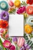 Blank white notecard mockup surrounded by colorful spring flowers and tulips for greeting cards