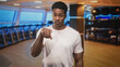 © Krakenimages.com - Man points finger at camera in studio gym among treadmills and a weight rack while wearing a white tshirt; challenge accountability.