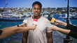 © Krakenimages.com - Man answering questions to reporters with microphones and smartphone at harbor pier, boats and town behind him; confidence public statement.