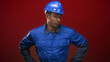 © Krakenimages.com - Man in blue hardhat and blue coveralls with hands on hips and smirk in studio as construction worker; quiet confidence.