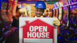 © Krakenimages.com - Man in blue hardhat and yellow gloves holds an open house sign and points to it inside a casino, showing shifts from smile to surprise across frames; cheerful promotion.